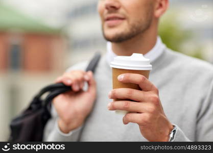 people, drinks and lifestyle - close up of man drinking coffee from disposable paper cup on city street