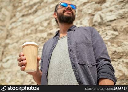 people, drinks, leisure and lifestyle concept - close up of man drinking coffee from disposable paper cup on city street