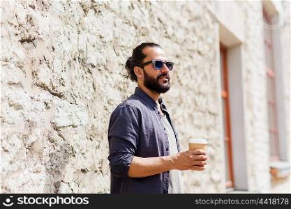 people, drinks, leisure and lifestyle - man drinking coffee from disposable paper cup on city street