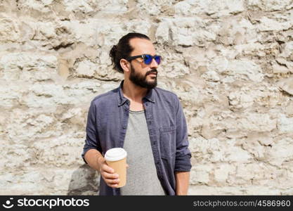 people, drinks, leisure and lifestyle - man drinking coffee from disposable paper cup on city street