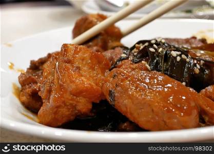 People eating honey glazed barbecued pork appetizers on table inside Chinese restaurant