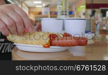 People eating hot dogs with coffee at table in convenience store