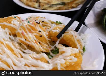 People eating pineapple shrimp ball on table inside Chinese restaurant