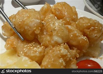 People eating pineapple shrimp ball on table inside Chinese restaurant