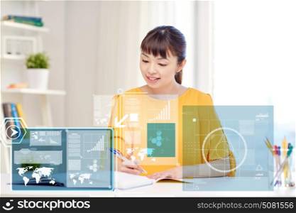 people, education and high school concept - happy asian young woman student with book and notepad writing at home. happy asian young woman student learning at home