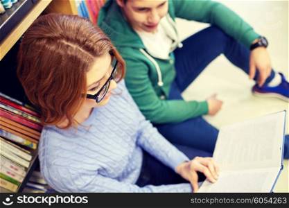 people, education and school concept - close up of happy students reading book in library