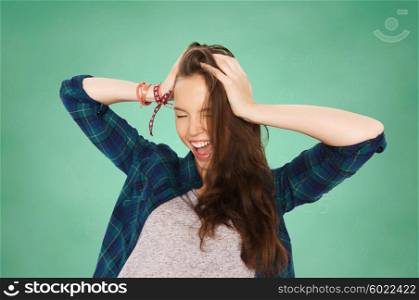 people, education and teens concept - happy pretty teenage student girl holding to head over green school chalk board background