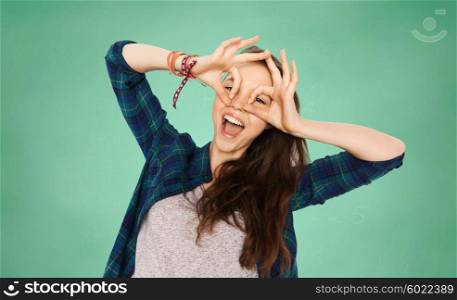 people, education and teens concept - happy smiling pretty teenage girl making face and having fun over green school chalk board background