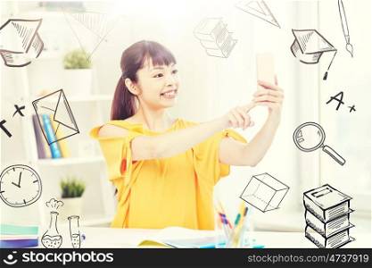 people, education, high school and learning concept - happy asian young woman student taking selfie with smartphone at home with doodles. asian woman student taking selfie with smartphone. asian woman student taking selfie with smartphone