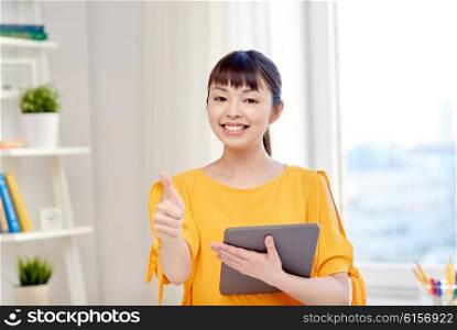 people, education, high school and learning concept - happy asian young woman student with tablet pc computer, book and notepads writing at home