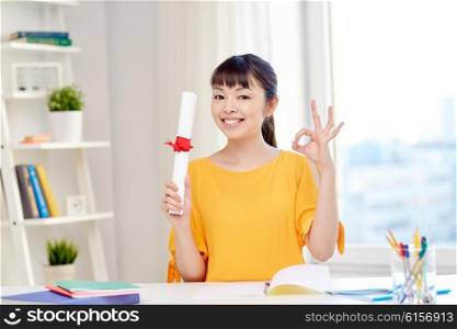 people, education, school, graduation and learning concept - happy asian young woman student with diploma scroll at home showing ok hand sign