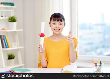 people, education, school, graduation and learning concept - happy asian young woman student with diploma scroll showing thumbs up at home