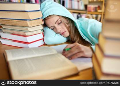 people, education, session, exams and school concept - tired student girl or young woman with books sleeping in library