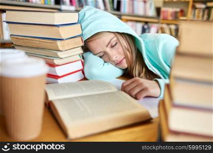 people, education, session, exams and school concept - tired student girl or young woman with books and coffee sleeping in library