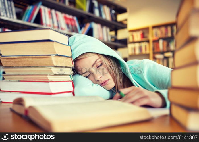 people, education, session, exams and school concept - tired student girl or young woman with books sleeping in library