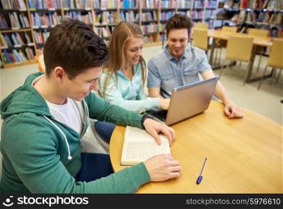 people, education, technology and school concept - happy students with laptop computer and books in library