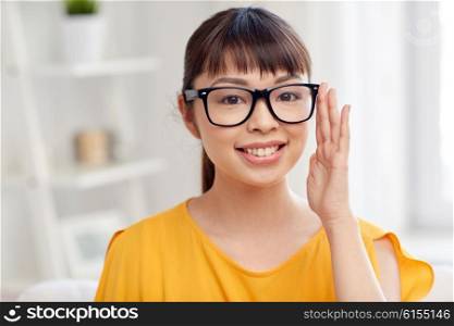 people, education, vision and portrait concept - happy asian young woman or teenage student girl in glasses at home