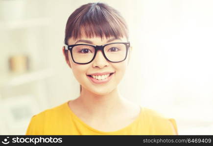 people, education, vision and portrait concept - happy asian young woman or teenage student girl in glasses at home. happy asian young woman in glasses at home