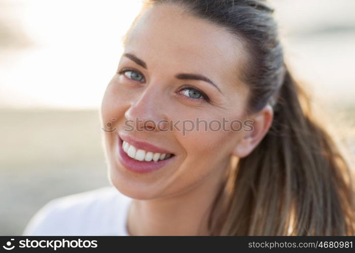 people, emotion and facial expression concept - close up of happy smiling young woman face outdoors