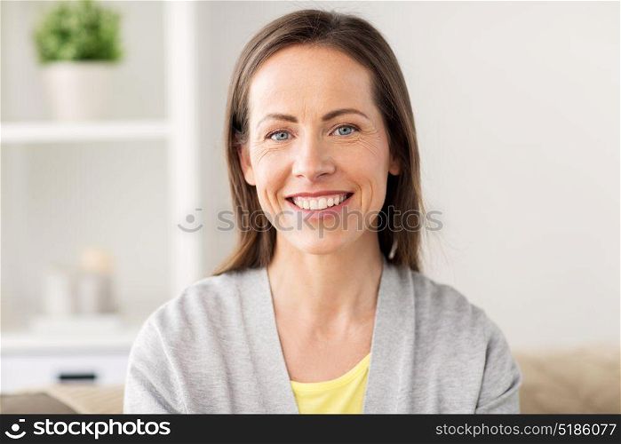 people, emotion and facial expression concept - happy smiling middle aged woman at home. happy smiling middle aged woman at home
