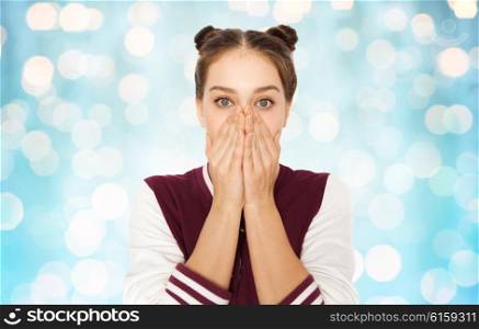 people, emotion, expression and teens concept - scared or confused teenage girl over blue holidays lights background