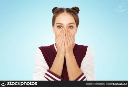 people, emotion, expression and teens concept - scared or confused teenage girl over blue background
