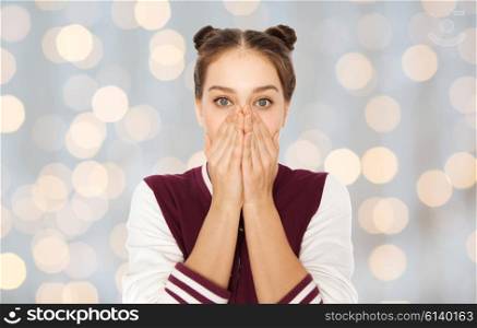 people, emotion, expression and teens concept - scared or confused teenage girl over holidays lights background