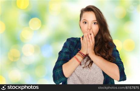 people, emotion, expression and teens concept - scared or surprised teenage girl over green holidays lights background