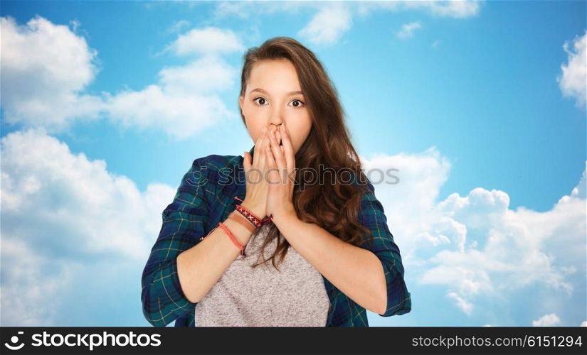 people, emotion, expression and teens concept - scared teenage girl over blue sky and clouds background