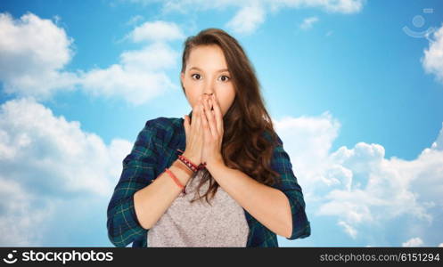 people, emotion, expression and teens concept - scared teenage girl over blue sky and clouds background