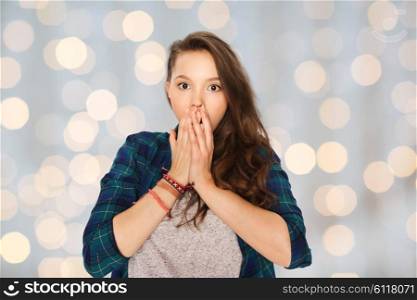 people, emotion, expression and teens concept - scared teenage girl over holidays lights background