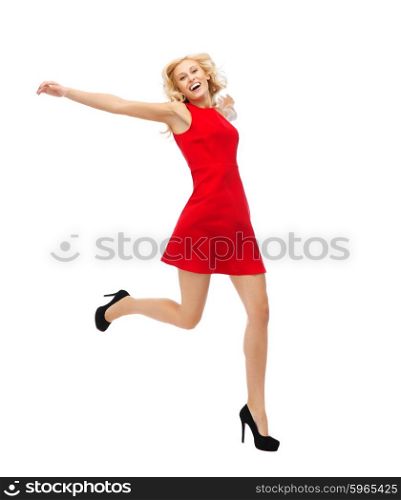 people, emotion, expression, happiness and holidays concept - happy young woman in red dress jumping high in air