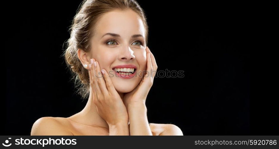 people, emotions and expressions concept - happy excited woman face over black background