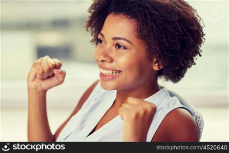 people, emotions, gesture and success concept - happy african american young woman with raised fists