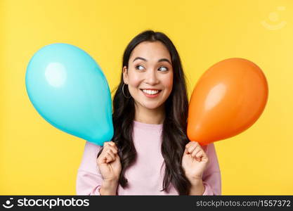 People emotions, lifestyle leisure and beauty concept. Beautiful dreamy asian girl with two balloons looking excited and intrigued at upper left corner, smiling cheerful, imagine lots of gifts.. People emotions, lifestyle leisure and beauty concept. Beautiful dreamy asian girl with two balloons looking excited and intrigued at upper left corner, smiling cheerful, imagine lots of gifts