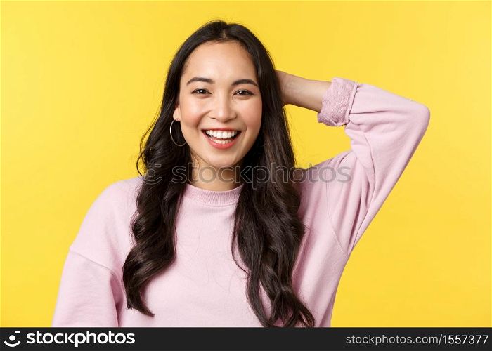 People emotions, lifestyle leisure and beauty concept. Close-up of friendly outgoing cute asian girl laughing and scratch back of head shy, receive praises for good job, stand yellow background.. People emotions, lifestyle leisure and beauty concept. Close-up of friendly outgoing cute asian girl laughing and scratch back of head shy, receive praises for good job, stand yellow background
