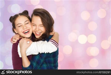 people, emotions, teens and friendship concept - happy smiling pretty teenage girls hugging and laughing over pink holidays lights background
