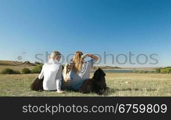 People enjoying in the nature with their Newfoundland dogs, rear view