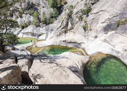 people enjoying the famous natural Pools of Purcaraccia Canyon in Bavella during summer, a tourist destination and attraction for canyoning and hiking. Corsica, France. Purcaraccia Canyon in Bavella, Corsica. France