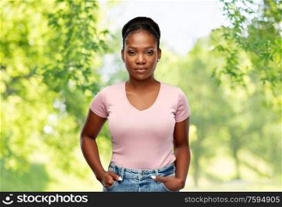 people, ethnicity and portrait concept - african american young woman over green natural background. african american woman over natural background