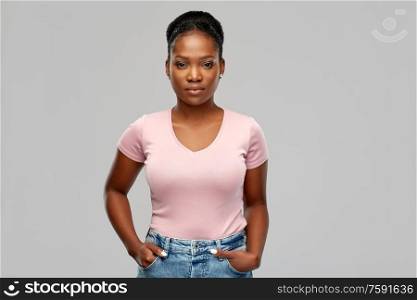 people, ethnicity and portrait concept - african american young woman over grey background. african american woman over grey background