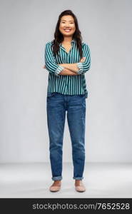 people, ethnicity and portrait concept - happy smiling asian young woman with crossed arms over grey background. happy smiling asian woman with crossed arms