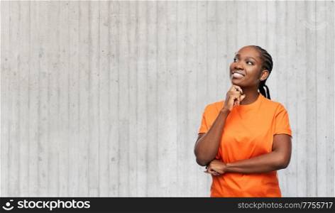 people, ethnicity and portrait concept - happy young woman dreaming over grey concrete wall background. happy woman dreaming over concrete wall