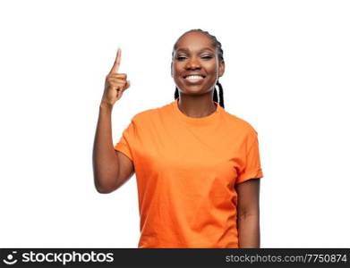 people, ethnicity and portrait concept - happy young woman pointing finger up over white background. happy woman pointing finger up