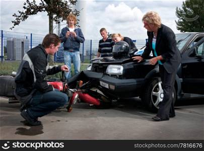 People examining the exterior damage to their vehicles after a car crash