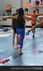 People Exercising with Plastic Water Bottle in Class at Gym with Music and Teacher on Stage.. People Exercising with Plastic Water Bottle in Class at Gym with Music and Teacher on Stage