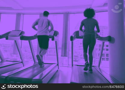 people exercisinng a cardio on treadmill in gym. young people exercisinng a cardio on treadmill running chine in modern gym duo tone filter