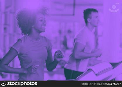 people exercisinng a cardio on treadmill. young people exercisinng a cardio on treadmill running machine in modern gym duo tone filter