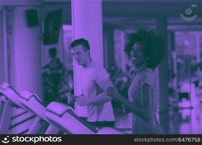 people exercisinng a cardio on treadmill. young people exercisinng a cardio on treadmill running machine in modern gym duo tone filter