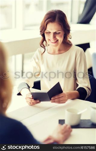 people, expenses, payment and lifestyle concept - happy woman looking at restaurant bill